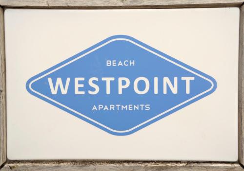 韋斯特貝的住宿－Westpoint Apartments，蓝路标志,上面读海滩西港仪器
