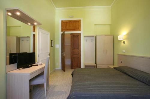 a bedroom with a bed and a desk with a computer at Hotel Primavera in Amadora