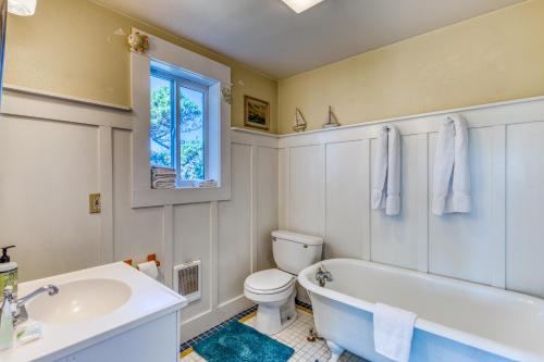 a bathroom with a tub and a toilet and a sink at Heceta House in Florence