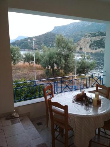 a room with a table and a balcony with a view at Armenaki Apartments in Sampatiki