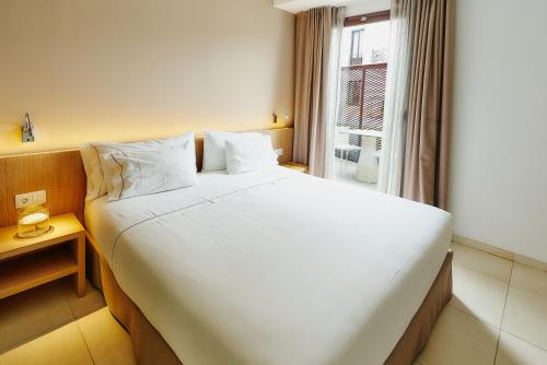 a large white bed in a room with a window at Hotel Arrey Alella in Alella