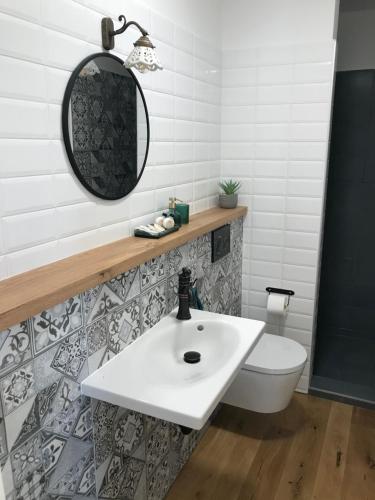 a bathroom with a white sink and a toilet at Ubytování Zahrada in Mutěnice