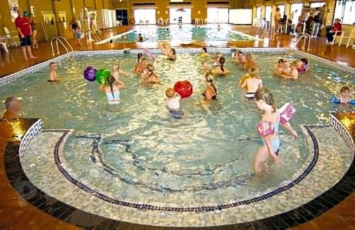 a group of children playing in a swimming pool at Beautiful Spacious Holiday Home - Romney Sands in New Romney