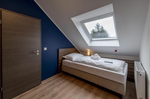 a attic bedroom with a bed with a window at Hotel Zu Freunden in Hamm