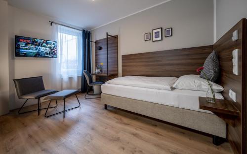 a bedroom with a bed and a desk and chairs at Hotel Zu Freunden in Hamm