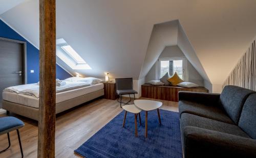Hotel Zu Freunden في هام: غرفة نوم في العلية مع سرير وأريكة