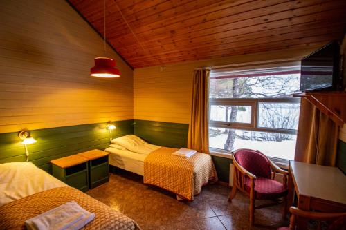 Tysfjord Hotel في Storjord I Tysfjord: غرفة صغيرة بسريرين ونافذة