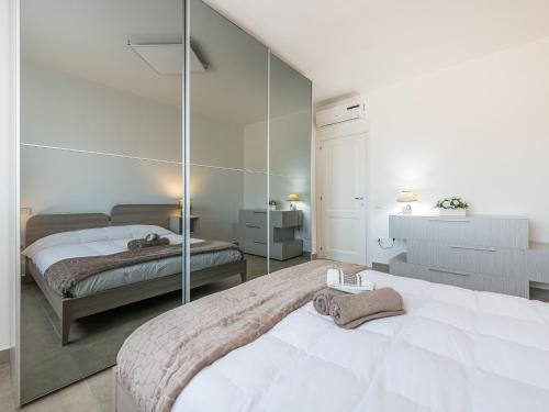 - une chambre avec 2 lits et un miroir mural dans l'établissement Casa Dani, à Villasimius