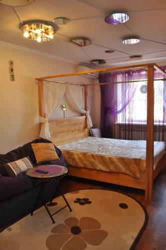 a bedroom with a bed and a couch at Cozy apartments near the McDonalds in Kremenchuk