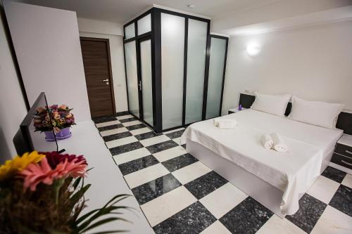 a room with a bed and a checkered floor at Casa Delia in Eforie Nord