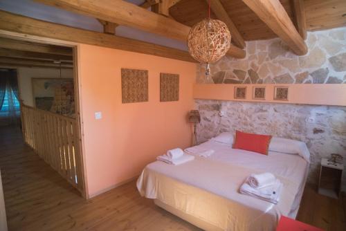 a bedroom with a bed and a stone wall at Old stone villa in Apokoronas Villa Nostalgia Kreta in Fílippos