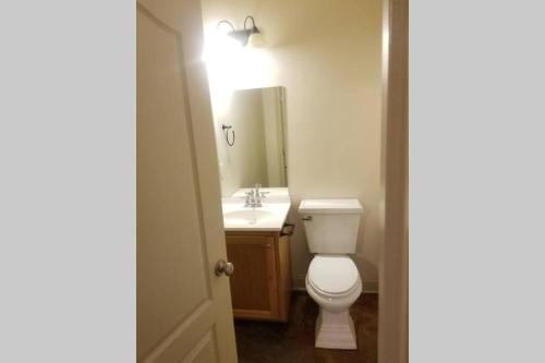 a bathroom with a white toilet and a sink at Villa 4 in Hammond