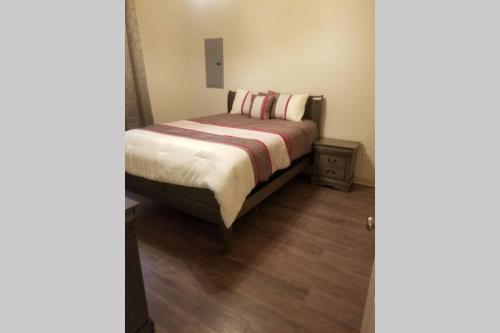 a small bedroom with a bed and a wooden floor at Villa 4 in Hammond