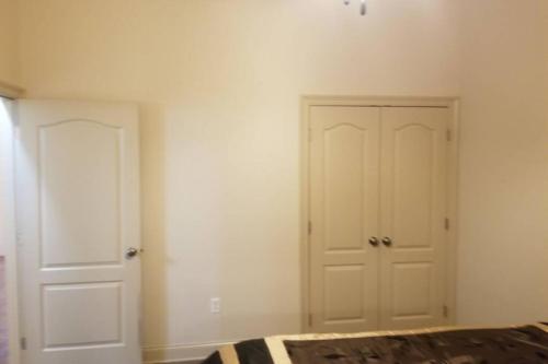 a bedroom with white walls and a white closet at Villa 4 in Hammond
