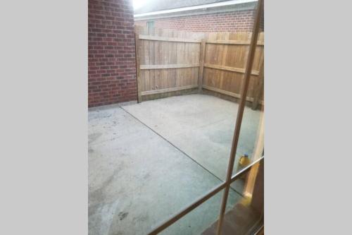 an empty backyard with a fence and a concrete floor at Villa 4 in Hammond