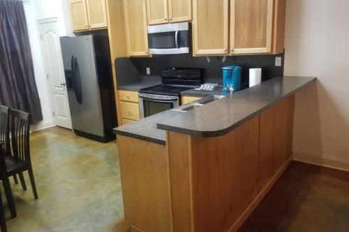 a kitchen with wooden cabinets and a black refrigerator at Villa 4 in Hammond