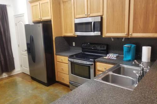 a kitchen with a stainless steel refrigerator and a sink at Villa 4 in Hammond
