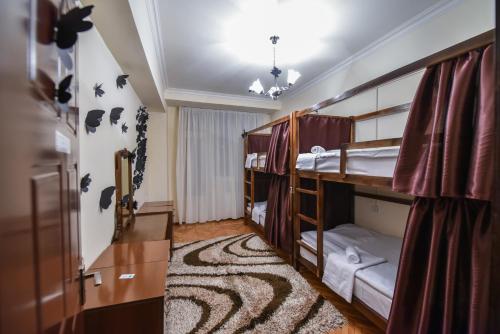 a room with three bunk beds and a carpet at Friendship Hostel & Tours in Yerevan