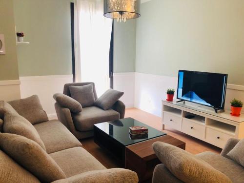 a living room with two couches and a flat screen tv at Sodic Westown Residence1-near Elnada hospital in ‘Izbat Yūsif Barrādah