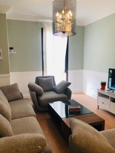 a living room with a couch and a coffee table at Sodic Westown Residence1-near Elnada hospital in ‘Izbat Yūsif Barrādah