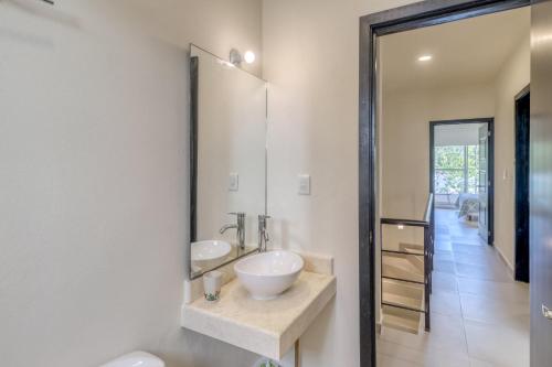 een badkamer met een wastafel en een spiegel bij Selvanova Coto 4B, Villa Flamingos 437F in Playa del Carmen