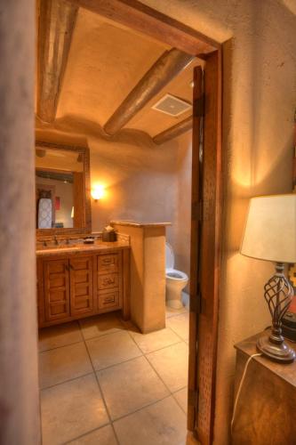 a bathroom with a toilet and a sink and a mirror at Inn at Vanessie in Santa Fe