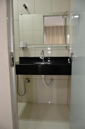 a bathroom with a sink and a mirror at Pousada e Restaurante MKE in João Pessoa