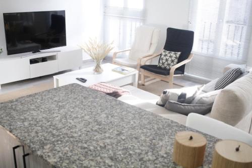 - un salon avec un canapé et une télévision dans l'établissement Apartamento Noia Centro Izqda, à Noia