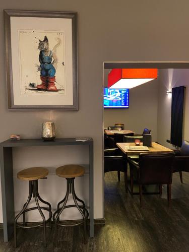 a waiting room with stools and a picture of a cat at Hotel Alte Redaktion in Gevelsberg