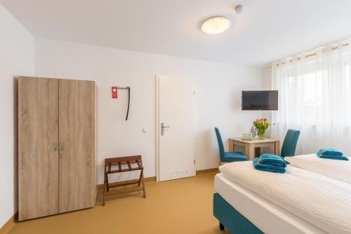 a hotel room with two beds and a tv at Hotel Ludwig in Munich