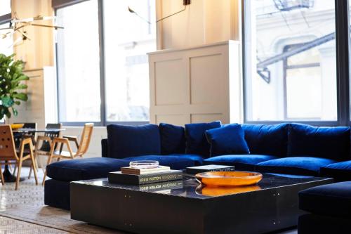 a living room with a blue couch and a coffee table at Walker Hotel Tribeca in New York