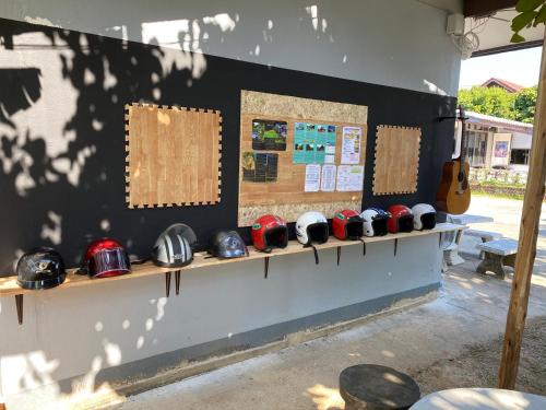 a wall with a shelf with helmets on it at Winter House Chiang Rai in Chiang Rai