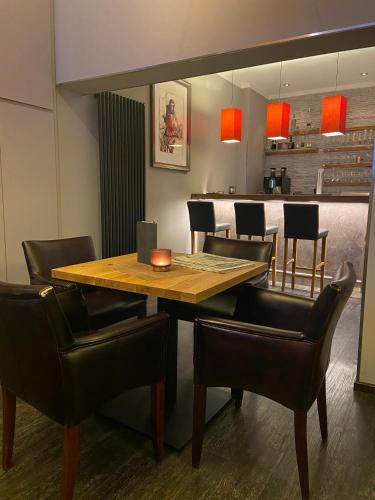 a dining room with a wooden table and chairs at Hotel Alte Redaktion in Gevelsberg