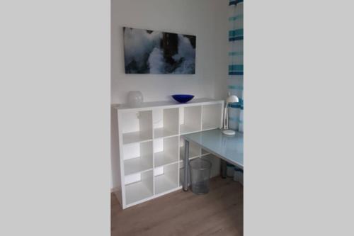 a room with a table and a blue bowl on a wall at Neues modern möbliertes Komfortappartement in Hilchenbach