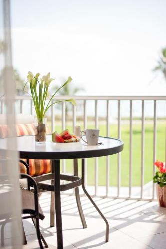 a table on a balcony with a coffee cup on it at Casa Ybel Resort in Sanibel