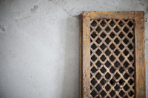 a rusty iron grate next to a wall at Nonam Boutique Hotel Gent in Ghent