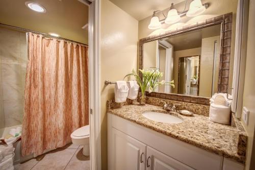 a bathroom with a sink and a toilet and a mirror at Casa Ybel Resort in Sanibel