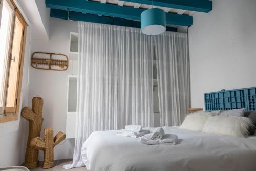 a bedroom with a bed with white sheets and a blue ceiling at Penthouse Torre del Mar Grupo AC Gestion in Cádiz