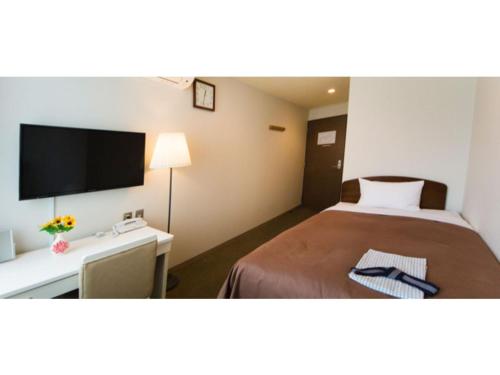 pokój hotelowy z łóżkiem i telewizorem z płaskim ekranem w obiekcie Grand Park Hotel Kazusa / Vacation STAY 77367 w mieście Kimitsu