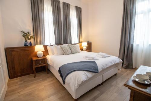 a bedroom with a large bed with two windows at Seven cafe & hotel in Pogradec