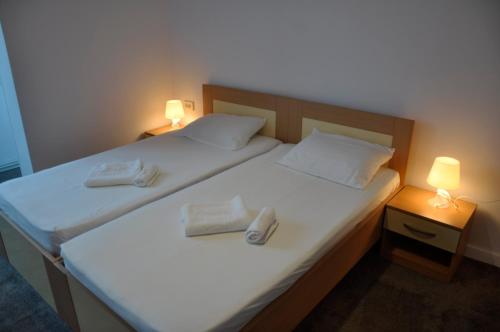 two beds in a room with two white towels on them at MANEA Orsova in Orşova
