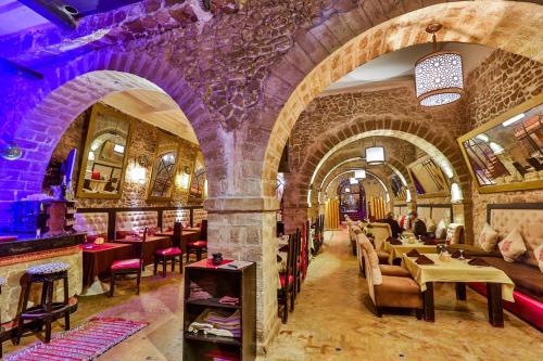 un restaurante con un montón de mesas y sillas en Hôtel Mechouar Plaza, en Essaouira