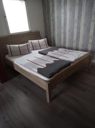 a bed with white sheets and red pillows on it at Ferienwohnung Schroiff in Simmerath