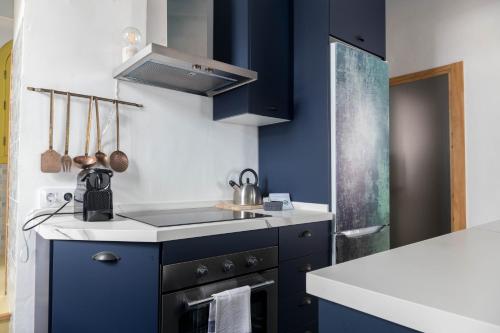 a kitchen with blue cabinets and a sink at Penthouse Torre del Mar Grupo AC Gestion in Cádiz