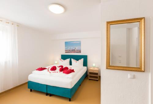a bedroom with a bed with red pillows and a mirror at Hotel Ludwig in Munich
