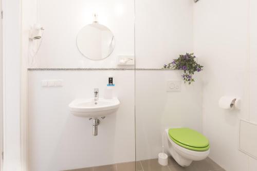 a bathroom with a green toilet and a sink at Hotel Ludwig in Munich