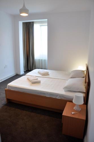 a large bed in a room with a window at MANEA Orsova in Orşova