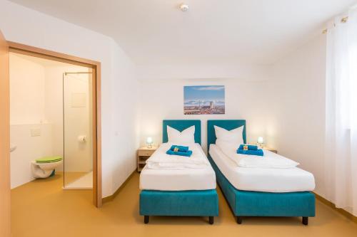 a bedroom with two beds and a mirror at Hotel Ludwig in Munich