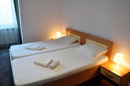 two beds in a room with white towels on them at MANEA Orsova in Orşova