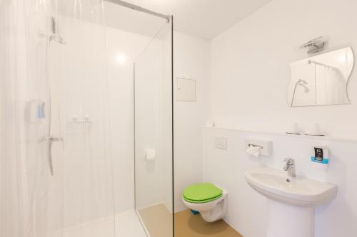 a bathroom with a shower, toilet, and sink at Hotel Ludwig in Munich